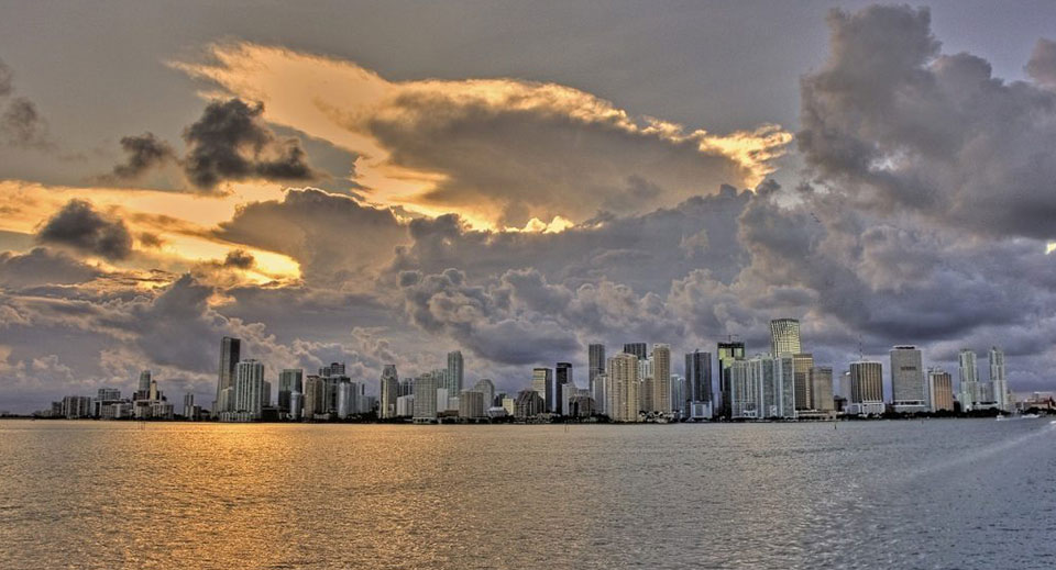 Miami skyline at sunset under storm clouds seen from the water